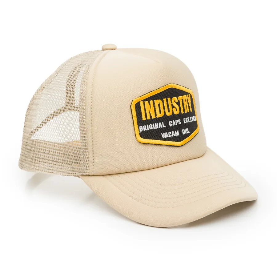 Gorra trucker beige con parche bordado sobre fondo blanco